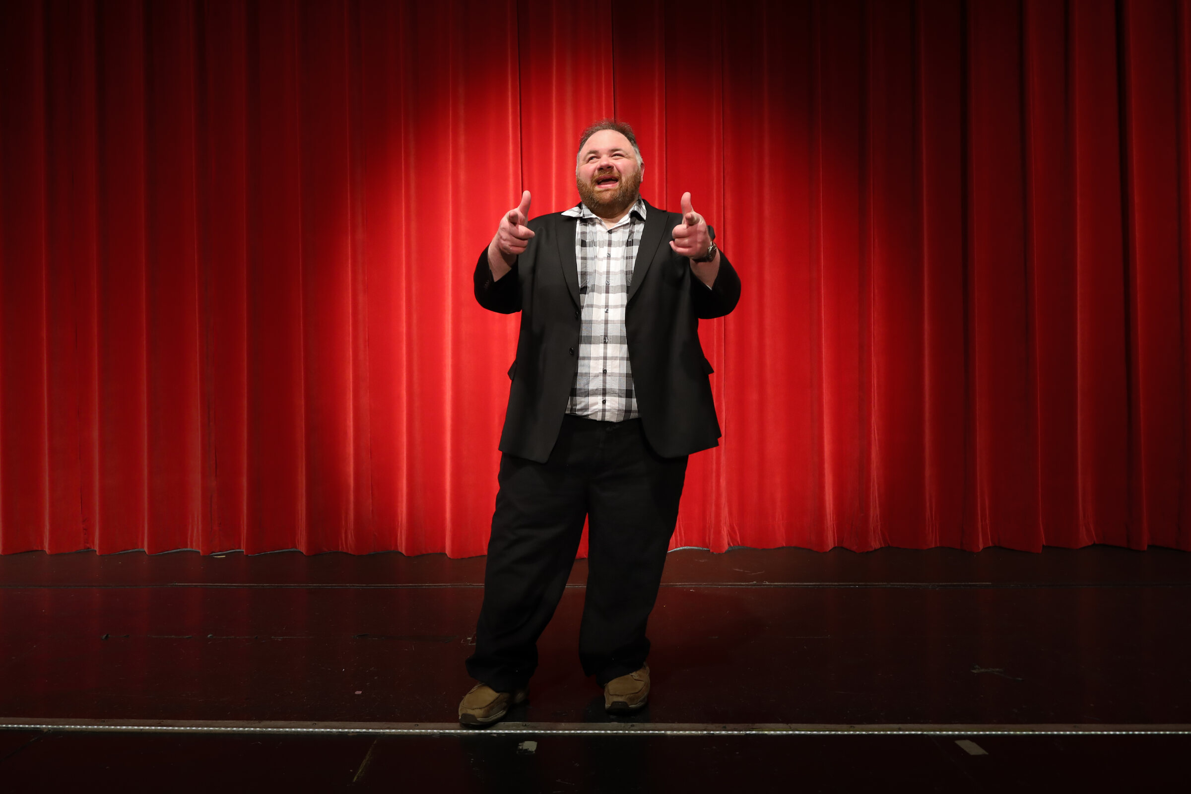 Kevin Lowe speaking with energy on a theater stage